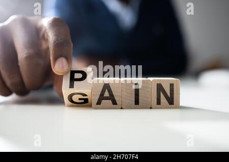 Idée de concept de gain de douleur avec mot de bloc en bois Banque D'Images