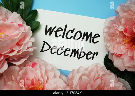 Bienvenue décembre texte typographique avec fleurs de pivoine sur fond bleu Banque D'Images