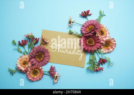 Texte typographique carte happy Thursday avec bouquet de fleurs sur fond bleu Banque D'Images