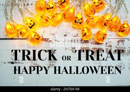 Trick or Treat typographie texte et Pumpkin Lights LED pour Halloween décorations sur fond en bois Banque D'Images