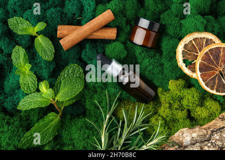 Ensemble de bouteilles de verre brun produits de beauté sur fond de mousse Banque D'Images