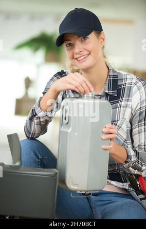 femme fixant un radiateur de chauffage à l'huile Banque D'Images