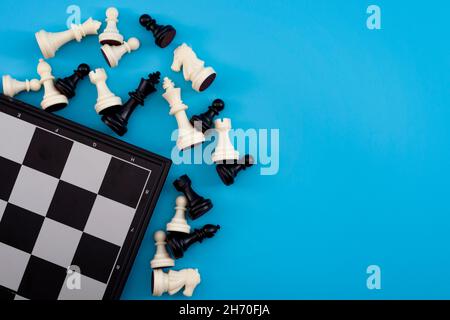 Pensée critique, tournoi d'échecs gagnant et concept de jeu d'esprit avec chessboard et figures isolées sur fond bleu avec espace de copie Banque D'Images