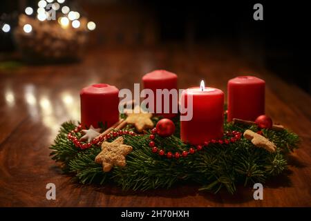 Premier Avent - couronne de l'Avent décorée de branches de sapin avec des bougies rouges sur une table en bois à l'époque avant Noël, bokeh festif dans le Banque D'Images