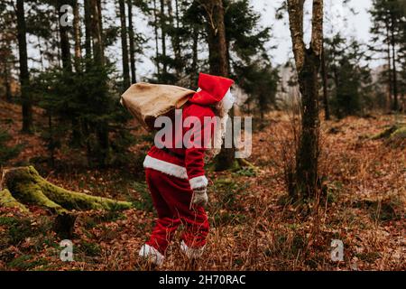 Homme portant un sac de transport de costume de Père Noël Banque D'Images