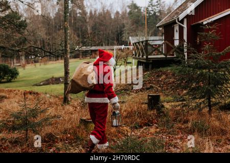 Homme portant un sac de transport de costume de Père Noël Banque D'Images