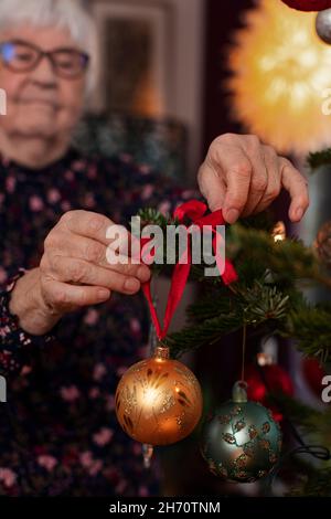 Woman decorating Christmas Tree Banque D'Images