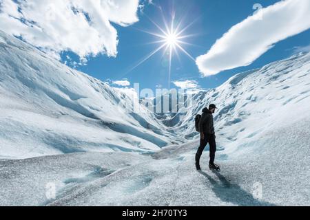 Un homme debout sur la formation de glace du glacier Perito Moreno et regardant en arrière Banque D'Images