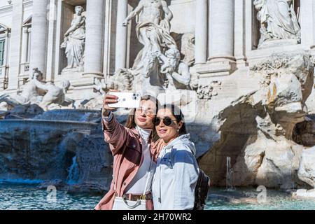 ROME ITALIE, 19 novembre 2021.Deux femmes prenant un selfie ensemble devant la fontaine de Trevi lors d'une belle journée ensoleillée à Rome avec des températures plus élevées que prévu atteignant 21cèle pour cette période de l'année.La fontaine de Trevi a été conçue par l'architecte italien Nicola Salvi et est l'un des plus célèbres et reconnaissables monuments au monde attirant de grandes foules de touristes toute l'année.Credit: amer ghazzal / Alamy Live News Banque D'Images