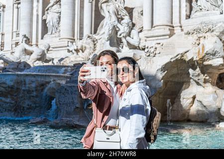 ROME ITALIE, 19 novembre 2021.Deux femmes prenant un selfie ensemble devant la fontaine de Trevi lors d'une belle journée ensoleillée à Rome avec des températures plus élevées que prévu atteignant 21cèle pour cette période de l'année.La fontaine de Trevi a été conçue par l'architecte italien Nicola Salvi et est l'un des plus célèbres et reconnaissables monuments au monde attirant de grandes foules de touristes toute l'année.Credit: amer ghazzal / Alamy Live News Banque D'Images