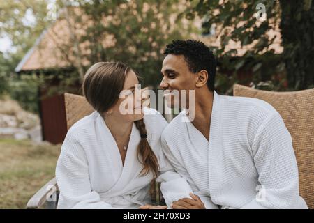 Smiling couple sitting in garden Banque D'Images