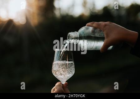 Personne versant de l'eau dans le verre Banque D'Images