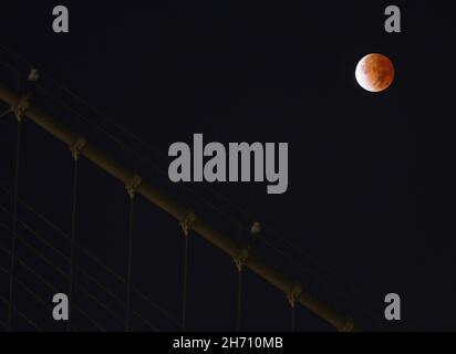 Brooklyn, États-Unis.19 novembre 2021.L'éclipse lunaire partielle la plus longue depuis des centaines d'années s'installe dans le ciel tôt le matin derrière le pont de Brooklyn à New York le vendredi 19 novembre 2021.C'était l'éclipse lunaire partielle la plus longue depuis le XVe siècle.Photo de John Angelillo/UPI crédit: UPI/Alay Live News Banque D'Images
