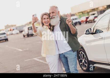 Photo de retraité retraité femme mari épousé gris cheveux vieux couple faire selfie v-sign carte parc à l'extérieur dans la ville urbaine Banque D'Images