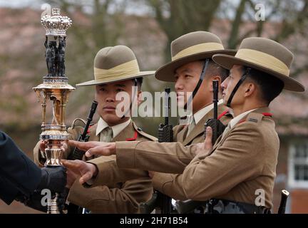 Trois chasseurs stagiaires des Royal Gurkha Rifles touchent les couleurs régimentaires connues sous le nom de matraque QueenÕs lors de la parade Kassam Khane à la caserne Sir John Moore à Shorncliffe, Folkestone, comme 70 soldats Gurkha récemment recrutés jurent le serment d'allégeance à leur régiment Royal Gurkha Rifles.Date de la photo : vendredi 19 novembre 2021. Banque D'Images