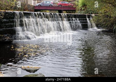 Chute d'eau coulant avec pont en métal et voitures en arrière-plan Banque D'Images