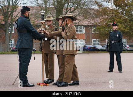 Trois chasseurs stagiaires des Royal Gurkha Rifles touchent les couleurs régimentaires connues sous le nom de matraque QueenÕs lors de la parade Kassam Khane à la caserne Sir John Moore à Shorncliffe, Folkestone, comme 70 soldats Gurkha récemment recrutés jurent le serment d'allégeance à leur régiment Royal Gurkha Rifles.Date de la photo : vendredi 19 novembre 2021. Banque D'Images