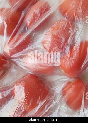 Fermez les tomates rouges dans un sac de cellophane. Banque D'Images