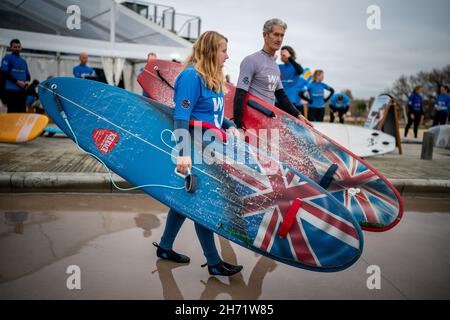 Charlotte Banfield, 23 ans, qui a la paralysie cérébrale, qui affecte l'utilisation de son bras et de ses jambes, avec l'entraîneur Mike Young, portent leurs planches de surf adaptées, comme ils prennent part à la session finale de l'entraînement de surf adaptatif Team English, à la vague, Bristol,Alors que l'équipe se prépare à se rendre aux Championnats du monde de surf ISA Para 2021 à Pismo Beach, en Californie.La compétition voit les meilleurs para-surfeurs du monde se réunir pendant une semaine pour participer et présenter le sport à un public mondial.Date de la photo : vendredi 19 novembre 2021. Banque D'Images