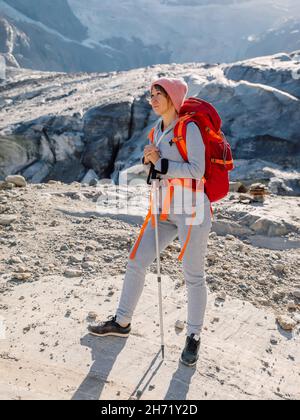Femme de randonnée avec sac à dos et bâtons de randonnée dans les montagnes.Montagne avec glacier et touristique Banque D'Images