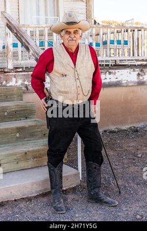 Un vieux cow-boy en robe d'époque guide une visite de la vieille ville fantôme de Shakespeare, Nouveau-Mexique. Banque D'Images