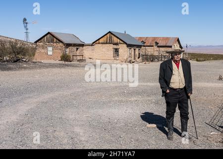 Un vieux cow-boy en robe d'époque guide une visite de la vieille ville fantôme de Shakespeare, Nouveau-Mexique. Banque D'Images