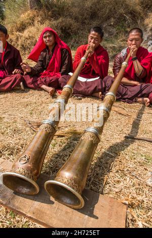 De jeunes moines bouddhistes pratiquant la corne tibétaine de dungchen à l'école monastique Dechen Phodrang à Thimphu, au Bhoutan. Banque D'Images