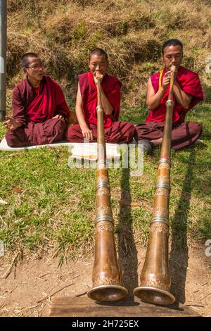 De jeunes moines bouddhistes pratiquant la corne tibétaine de dungchen à l'école monastique Dechen Phodrang à Thimphu, au Bhoutan. Banque D'Images