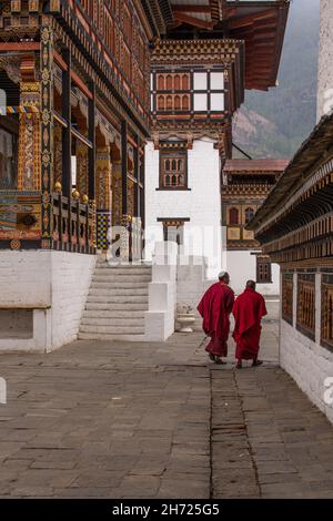 Deux moines bouddhistes marchant à l'intérieur du complexe Thimphu Dzong à Thimphu, au Bhoutan. Banque D'Images