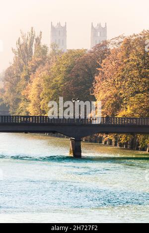 Munich, pont Bosch sur la rivière Isar avec les tours de l'église St Maximilian, vue automnale par une journée ensoleillée de brouillard Banque D'Images