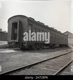 Photo en échelle de gris d'une locomotive vapeur dans un chemin de fer du XIXe siècle Banque D'Images