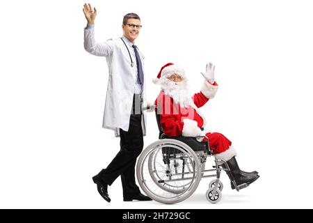 Prise de vue en profil d'un médecin poussant le père noël dans un fauteuil roulant et en agitant la caméra isolée sur fond blanc Banque D'Images