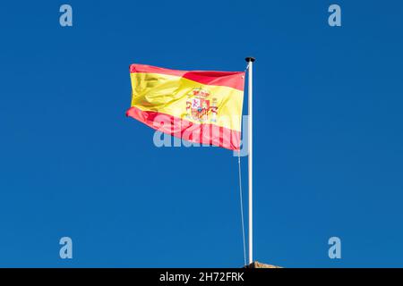 Drapeau de l'espagne sur le mât soufflant dans le vent Banque D'Images