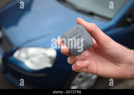 Un jeune conducteur sur le point d'installer une boîte noire télématique d'assurance automobile au Royaume-Uni dans sa nouvelle voiture. Banque D'Images