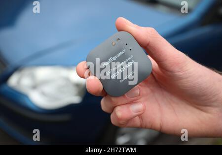Un jeune conducteur sur le point d'installer une boîte noire télématique d'assurance automobile au Royaume-Uni dans sa nouvelle voiture. Banque D'Images