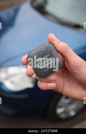 Un jeune conducteur sur le point d'installer une boîte noire télématique d'assurance automobile au Royaume-Uni dans sa nouvelle voiture. Banque D'Images