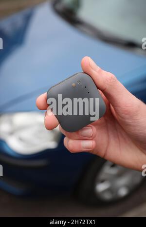 Un jeune conducteur sur le point d'installer une boîte noire télématique d'assurance automobile au Royaume-Uni dans sa nouvelle voiture. Banque D'Images