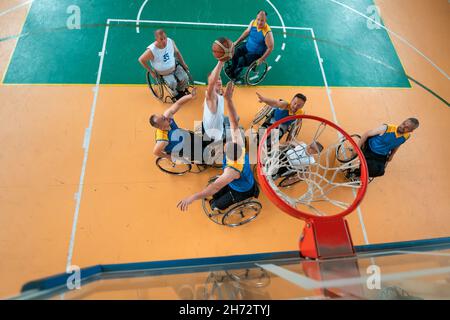 Les vétérans handicapés de guerre ou de travail ont mélangé des équipes de basket-ball de race et d'âge en fauteuil roulant jouant un match d'entraînement dans une salle de sport.Personnes handicapées Banque D'Images