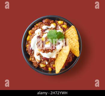 bol de cuisine mexicaine chili con carne isolé sur fond marron, vue de dessus Banque D'Images
