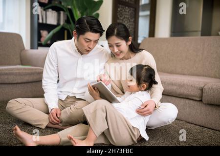 Une jeune famille heureuse utilisant une tablette numérique à la maison Banque D'Images
