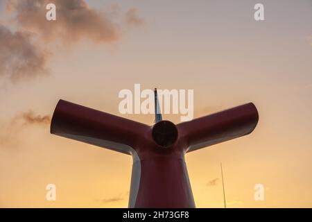 Saint Vincent - 13 mai 2020 : photo en petit angle d'entonnoir rouge, blanc et bleu sur Carnaval Freedom.Magnifique coucher de soleil orange avec des nuages dans l'arrière-plan Banque D'Images