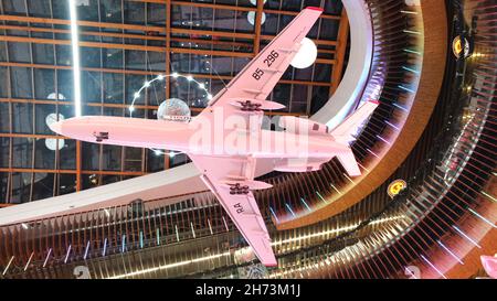 Vue de dessous sur le modèle d'avion blanc suspendu contre le beau plafond avec éclairage en forme d'objets de l'espace extérieur.Muse Banque D'Images