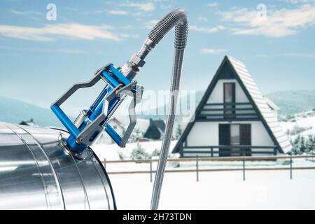 Buse GNC avec réservoir de gaz sur fond de maison d'hiver.Concept de chauffage au gaz Banque D'Images