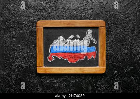 Tableau noir avec drapeau russe dessiné sur fond noir Banque D'Images