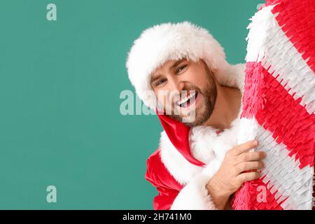 Père Noël avec pinata de canne à sucre sur fond vert Banque D'Images