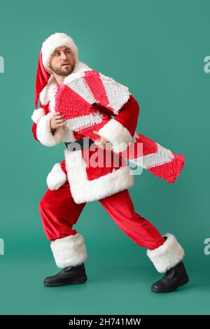 Père Noël avec pinata de canne à sucre sur fond vert Banque D'Images