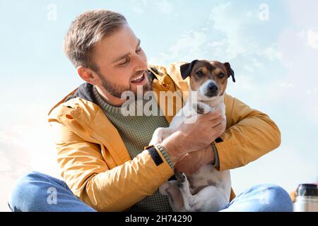 Bel homme avec un drôle de terrier Jack Russel le jour de l'automne Banque D'Images