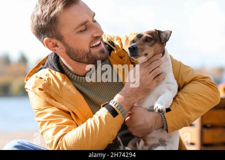 Bel homme avec un drôle de terrier Jack Russel le jour de l'automne Banque D'Images