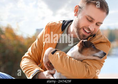 Bel homme avec un drôle de terrier Jack Russel le jour de l'automne Banque D'Images