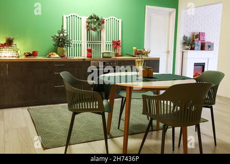 Table à manger avec verres de champagne et cadeau dans la cuisine décorée pour Noël Banque D'Images
